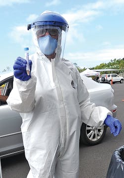 Volunteer Lori Cannon, flight nurse for Hawaii Life Flight, displays a swab taken from a qualifying patient at the Old Kona Airport drive up testing for COVID-19. Volunteer Lori Cannon, flight nurse for Hawaii Life Flight, displays a swab taken from a qualifying patient at the Old Kona Airport drive up testing for COVID-19.
