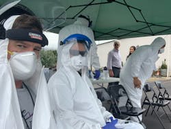 EMS professionals preparing for the screening of temperature, blood pressure, and review of histories. EMS professionals preparing for the screening of temperature, blood pressure, and review of histories.