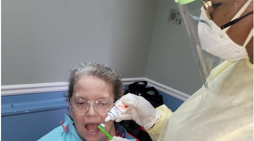 Sonya Dunbar, MHA, RDH, checks the oral health of a senior resident in a long-term care facility.