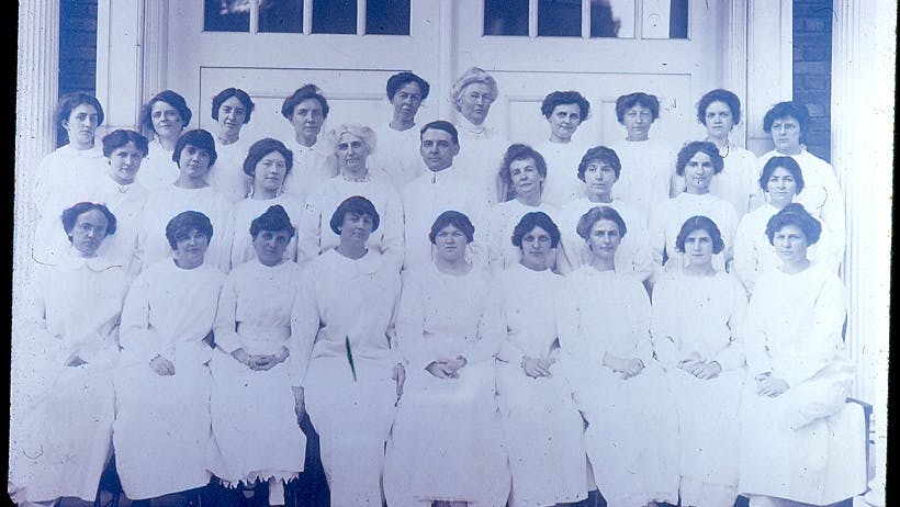 First graduating class of Fones School of Dental Hygiene 1914. Dr. Alfred Fones is in the center of the photo with Irene Newman on his right (blond woman) and his wife Elizabeth on his left.