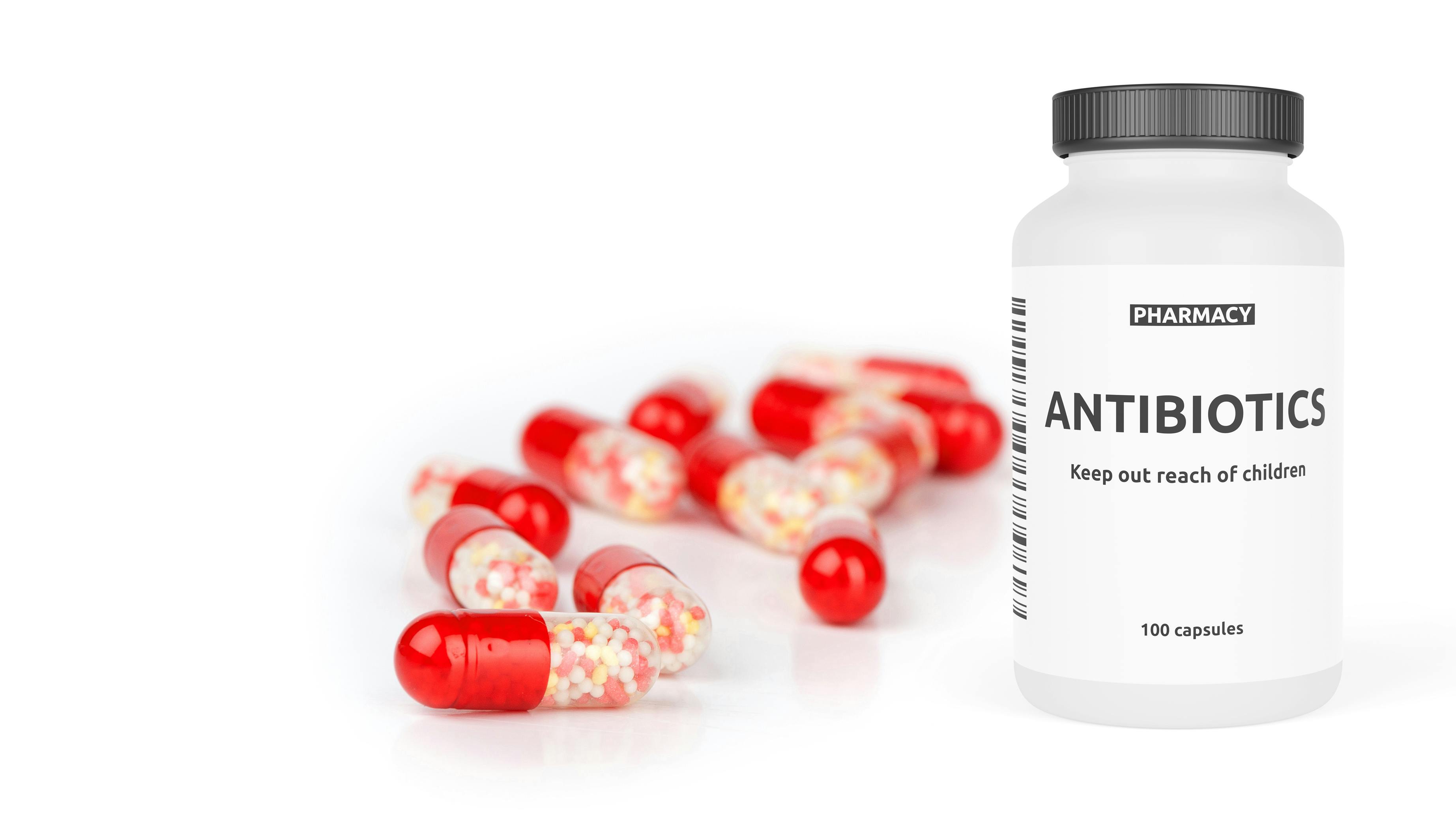 bottle-of-antibiotics-with-pills-beside-it
