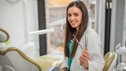 dental-pro-holding-hand-instrument-in-operatory dental-pro-holding-hand-instrument-in-operatory