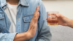 person gesturing 'no' to a glass of alcohol person gesturing 'no' to a glass of alcohol