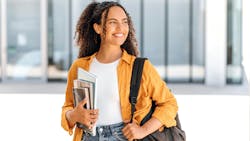 smiling woman holding books and a backpack smiling woman holding books and a backpack