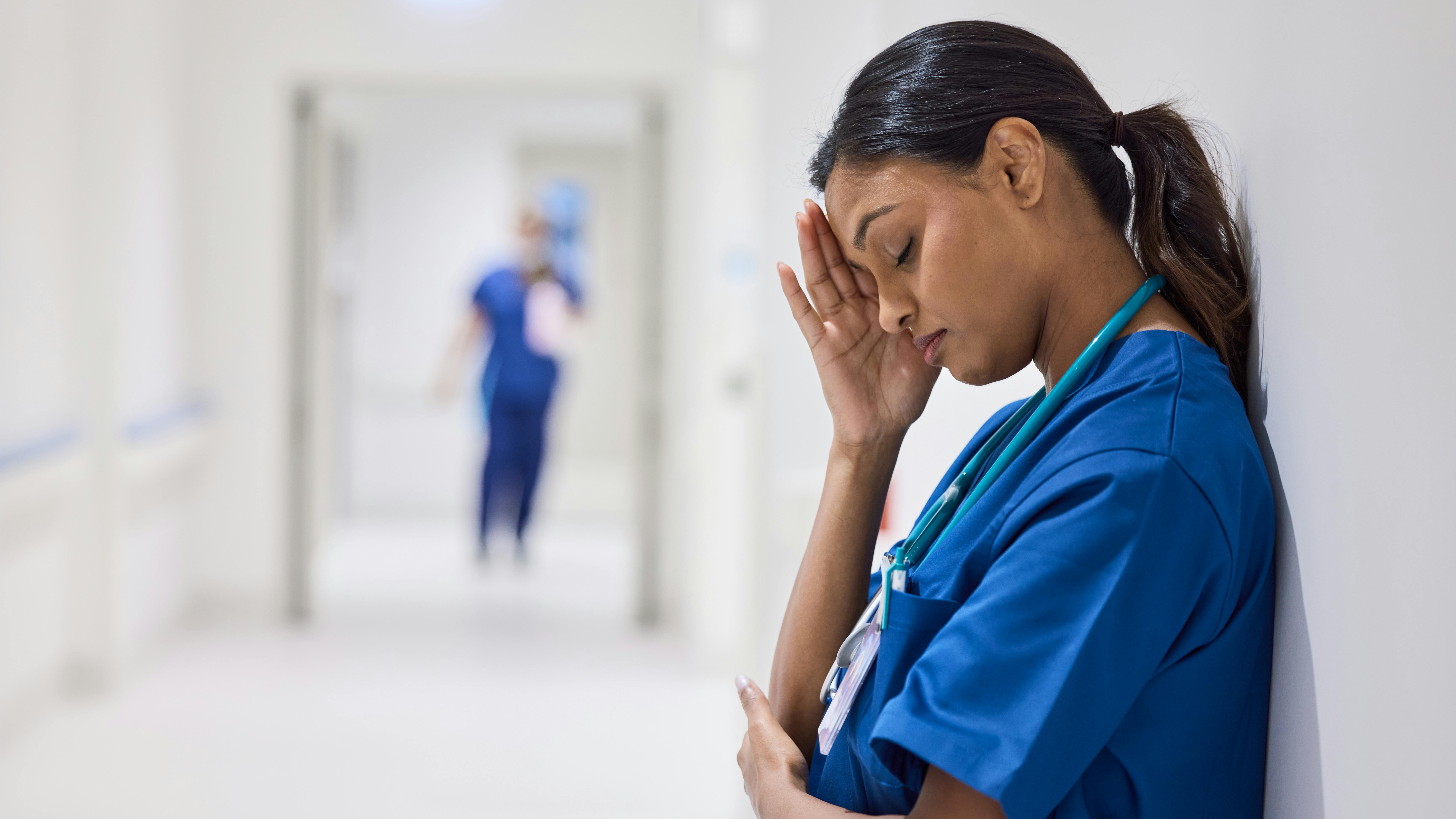 dental hygienist with her hand on her face, feeling frustrated with the lack of authority