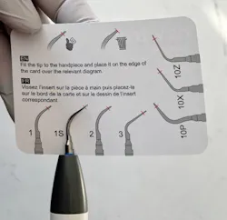 hand holding an ultrasonic tip wear guide for dental hygiene