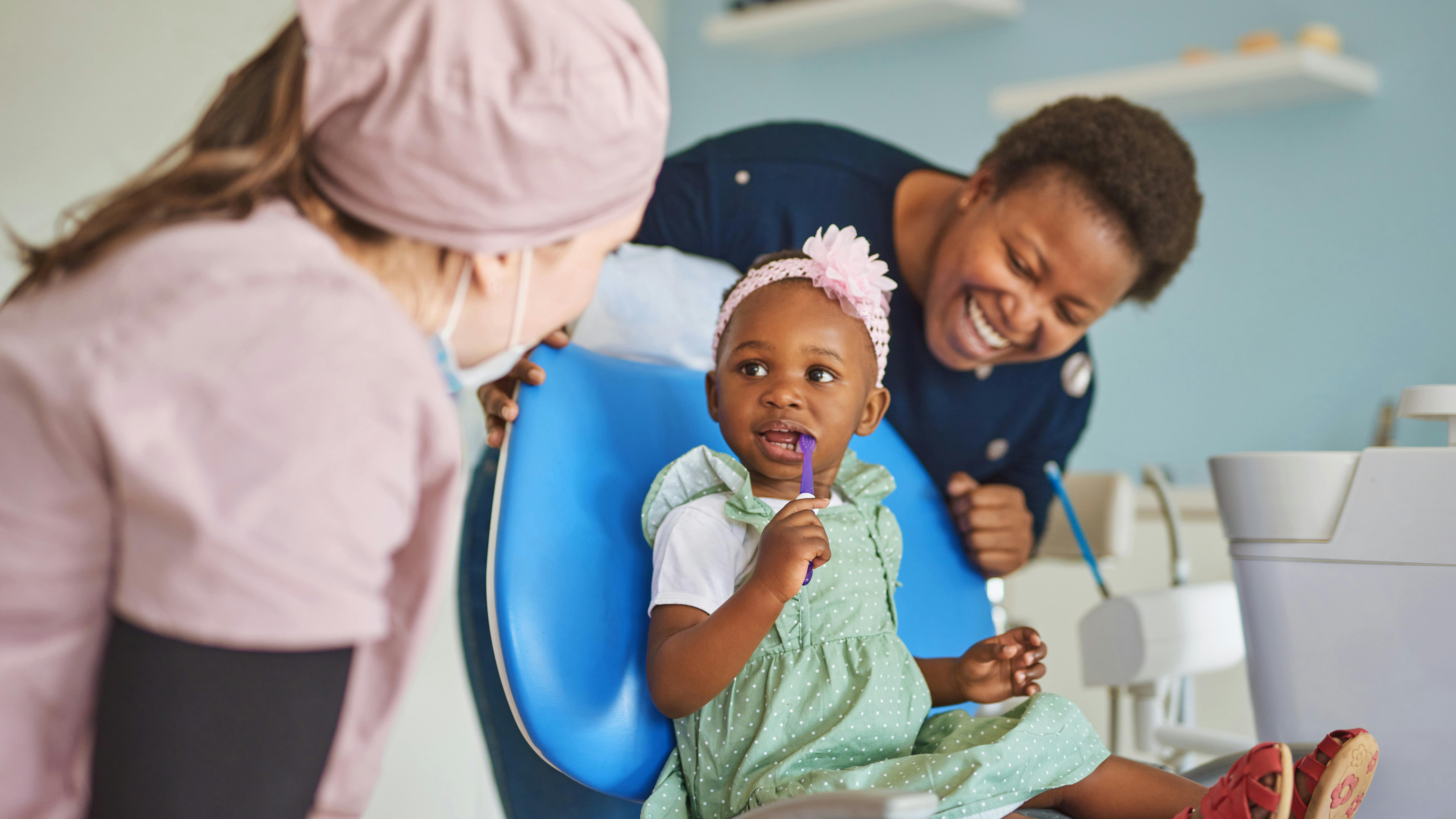 a little girl sitting in a dental chair