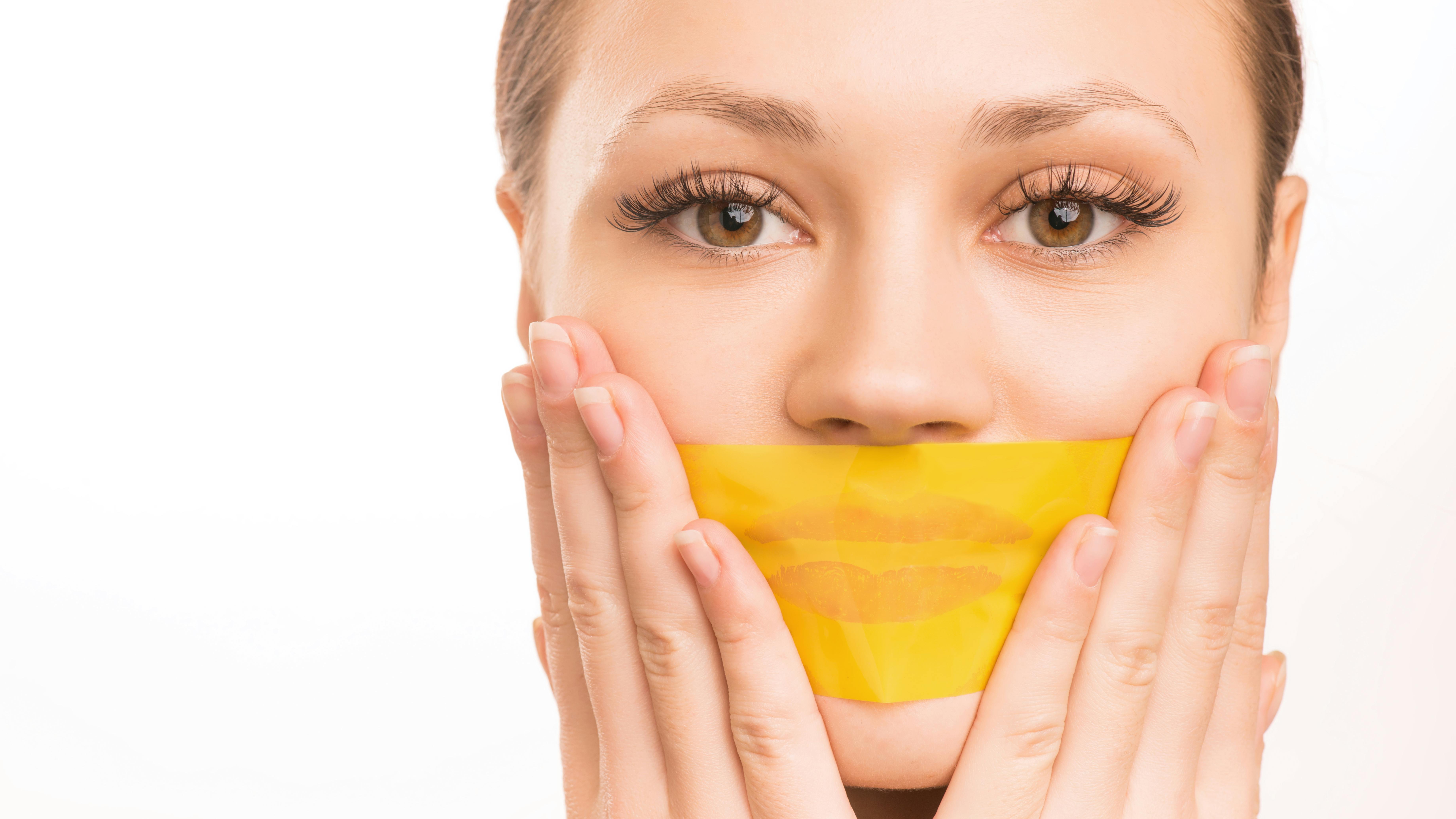 woman holding tape over her mouth