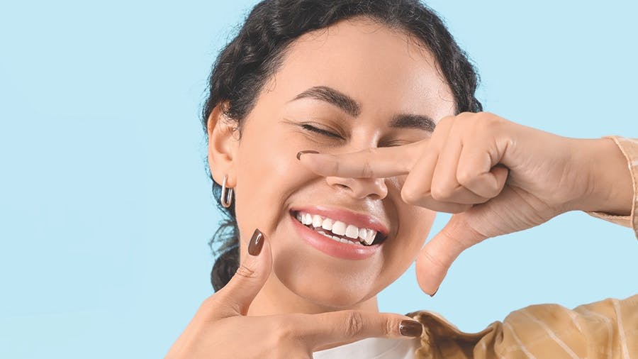 a smiling lady framing her mouth with her hands