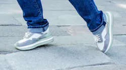 A person's feet walking over uneven pavement
