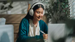 dental student with headphones and a smile sitting at a laptop dental student with headphones and a smile sitting at a laptop