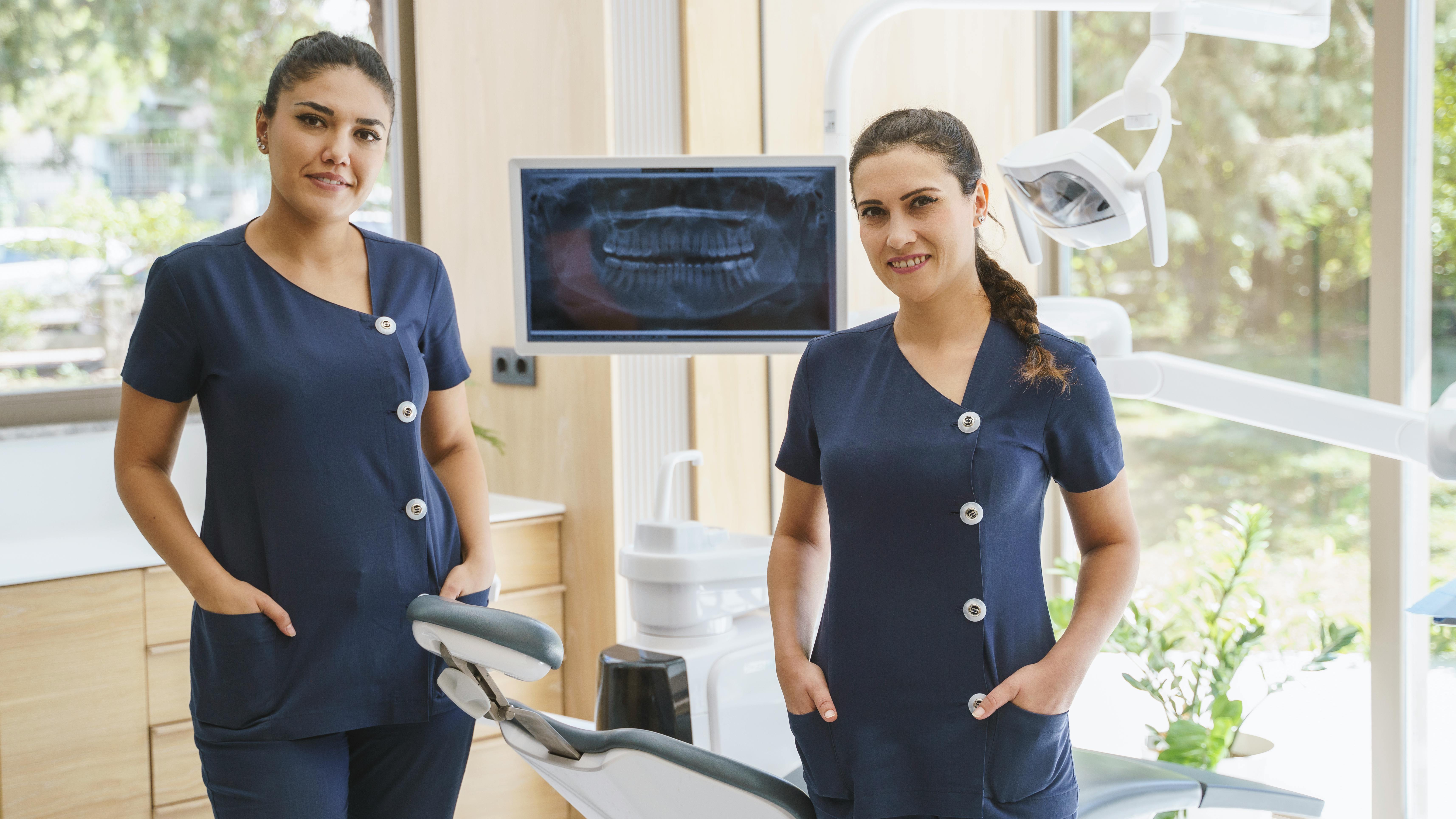 two dental team members standing in a dental operatory
