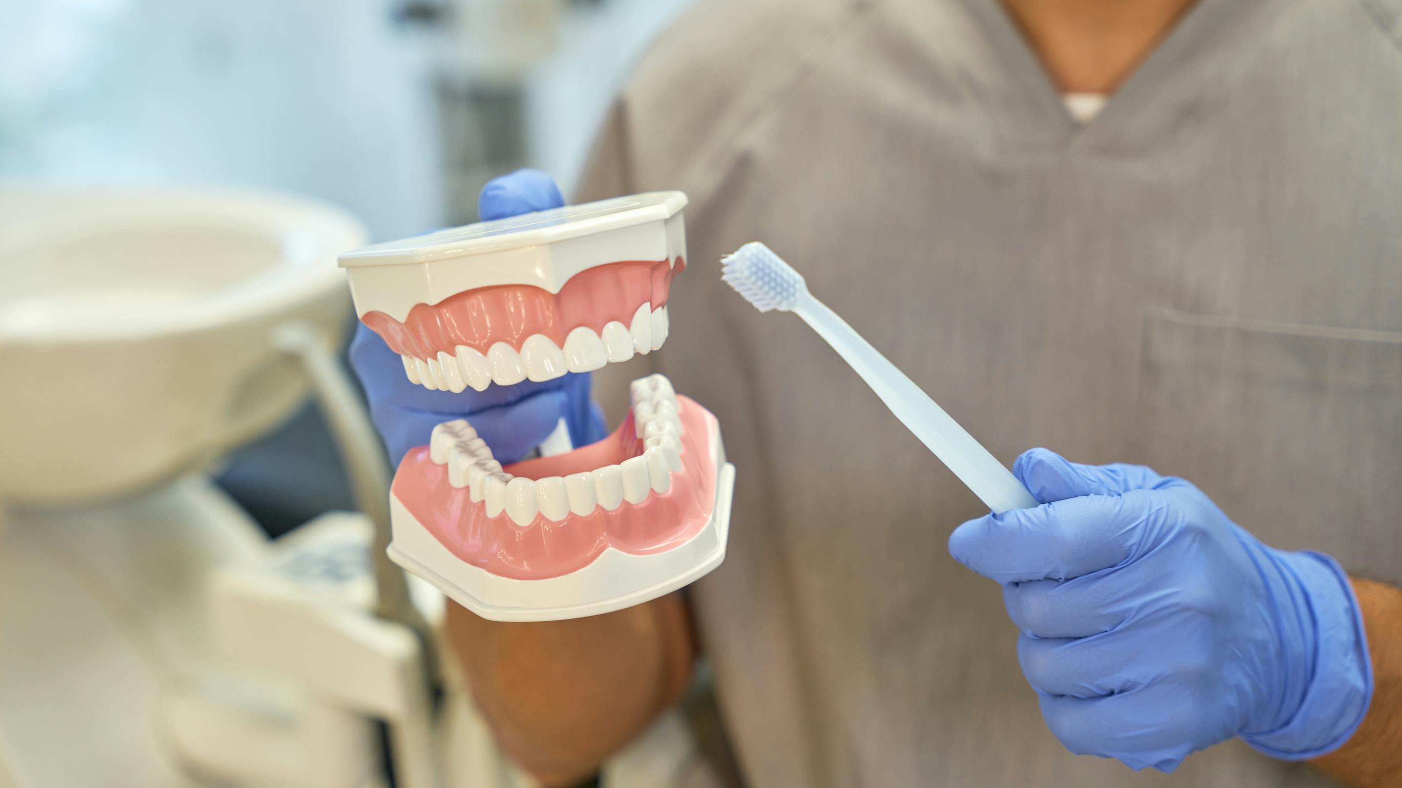 Dental hygienist adapting oral hygiene instruction for patient with visual impairment