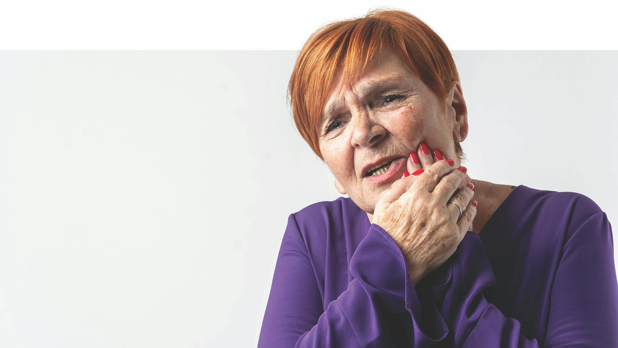 woman holding her face due to dental pain