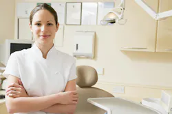 a smiling dental hygienist standing in an operatory a smiling dental hygienist standing in an operatory