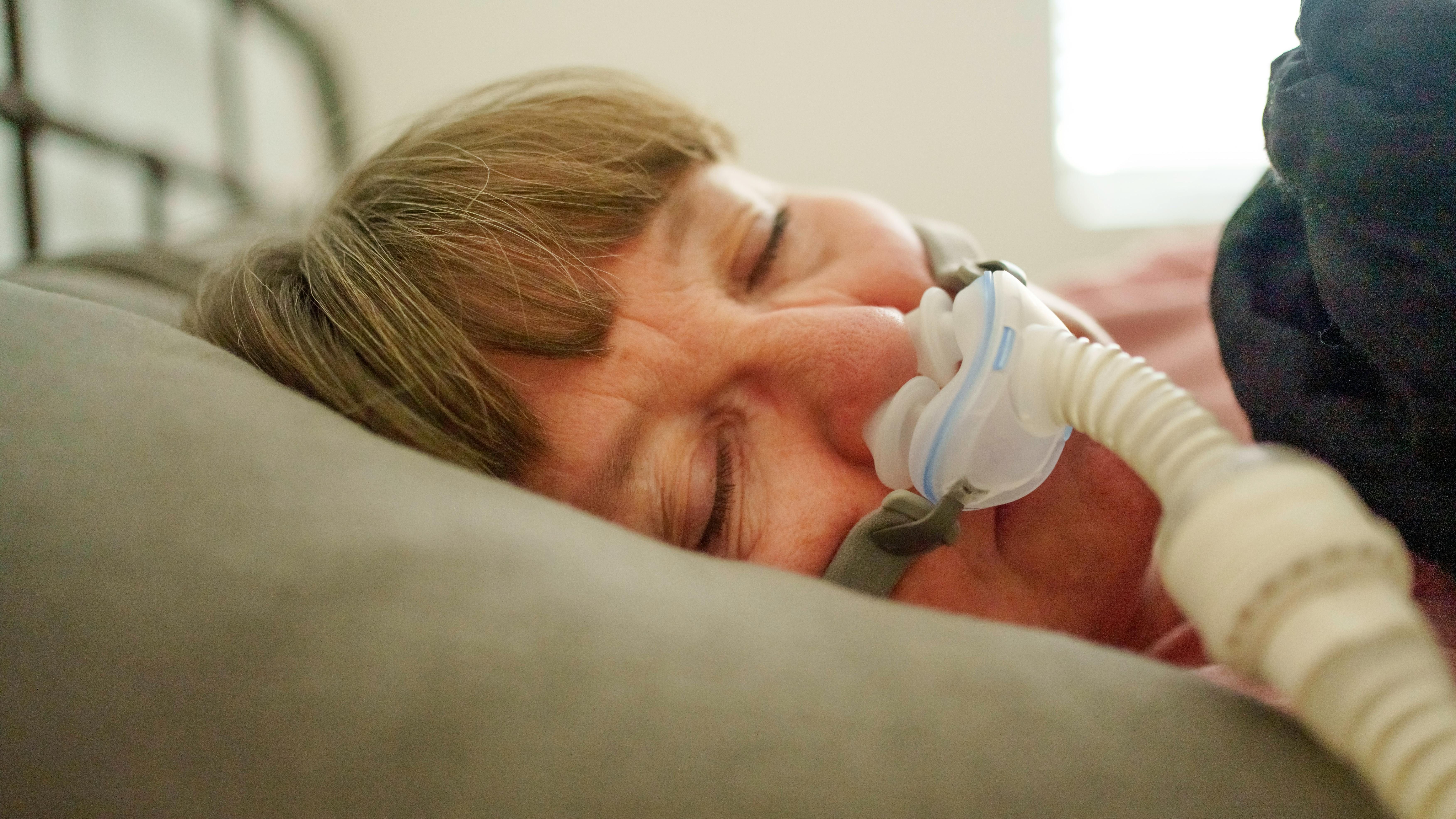 woman sleeping with a CPAP machine