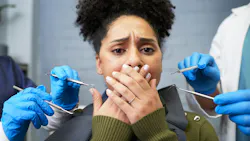 anxious dental patient with her hands over her mouth