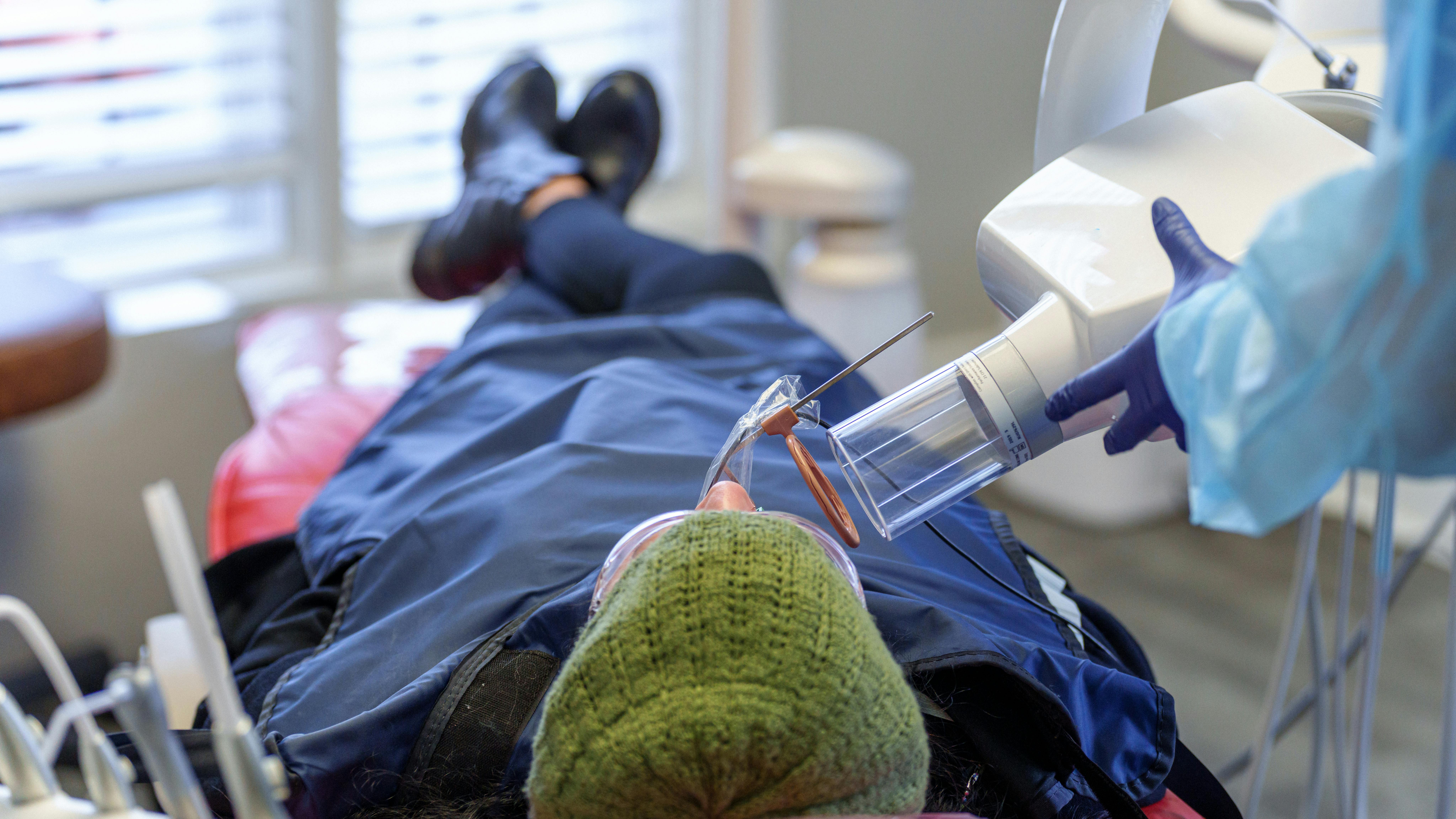 patient lying in a dental chair getting an x-ray taken