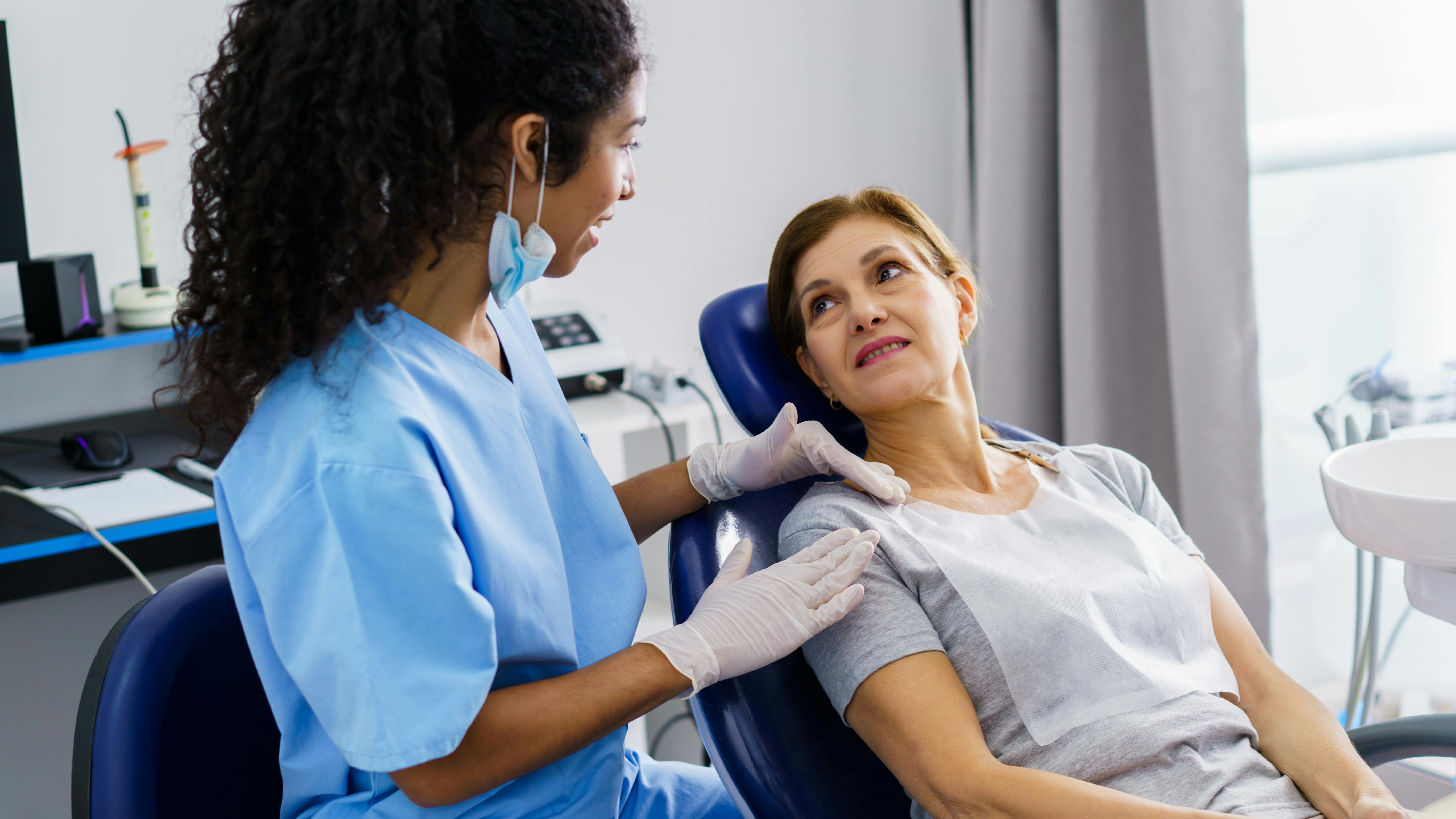 hygienist placing her hand on a patient's shoulder in a caring manner