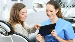 dental hygienist showing a patient something on a tablet