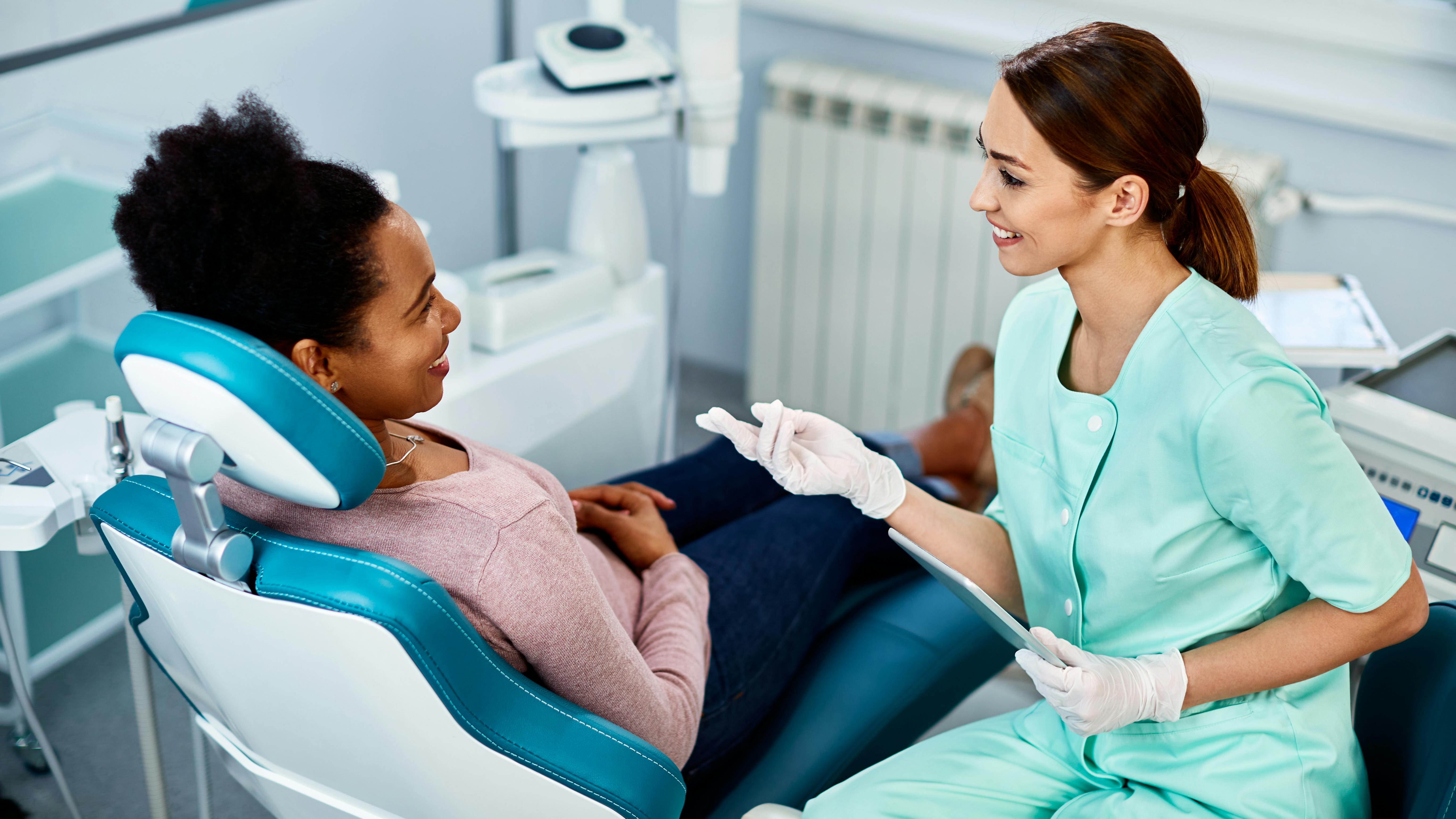 dental hygienist talking to a patient in the chair