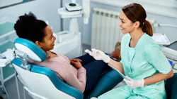dental hygienist talking to a patient in the chair