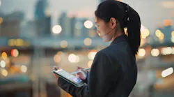 woman looking down at a tablet with bokeh in the background