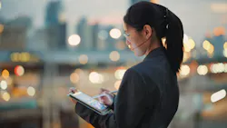 woman looking down at a tablet with bokeh in the background