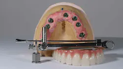 Image of a dental typodont along with a torque wrench used for implants