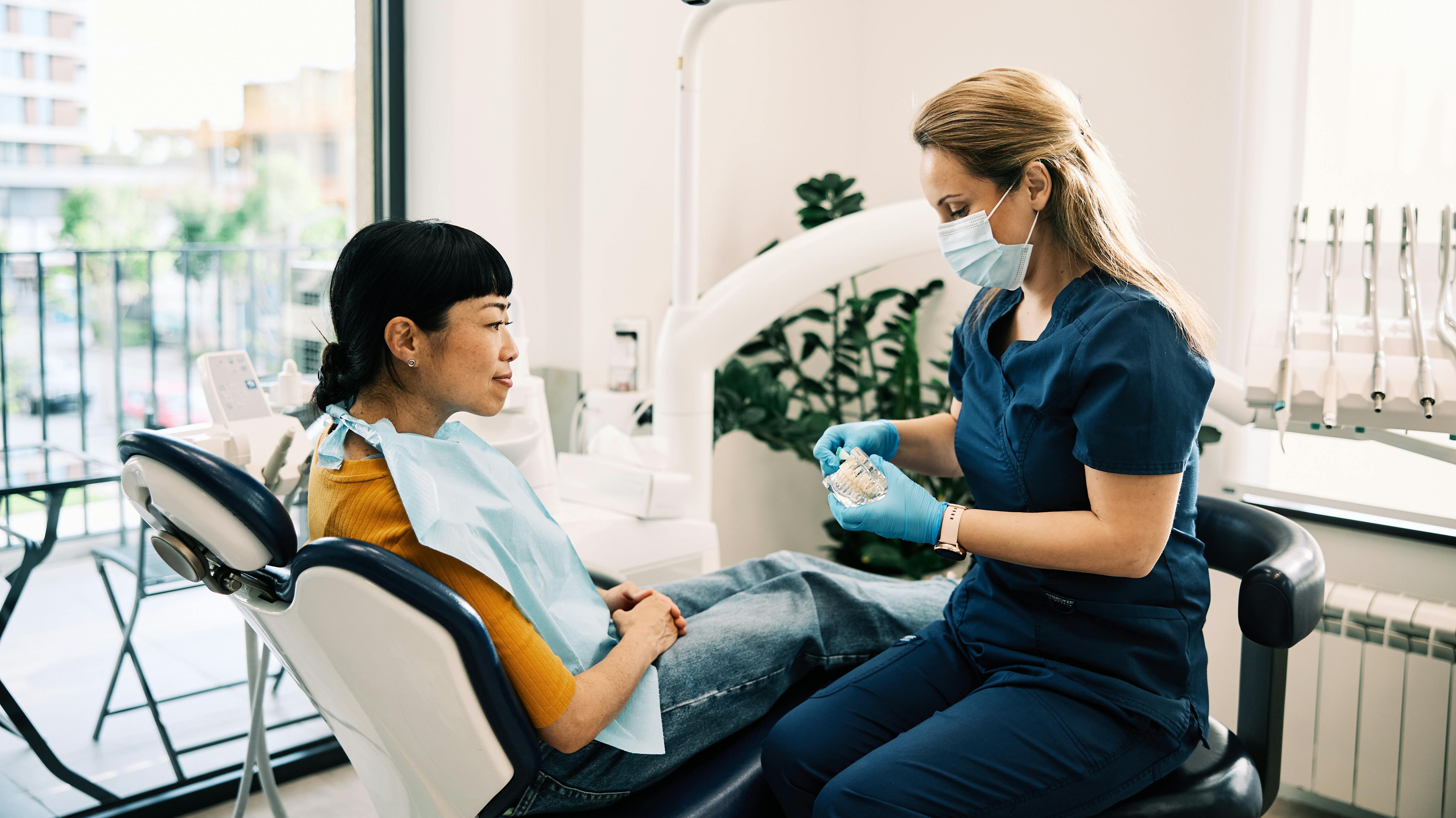 Dental hygienist discussing patient care and clinical findings with a patient